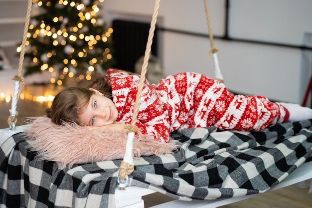 A little girl in pajamas can't sleep on a festive night