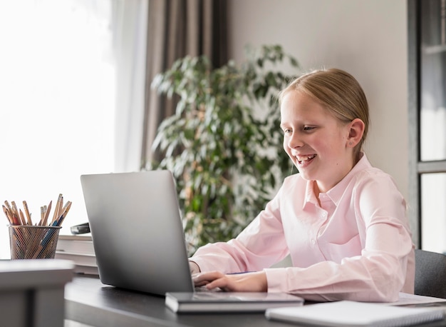 Photo little girl participating in online class at home