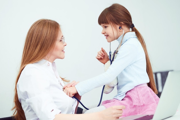 Little girl patient examining female doctor in hospital