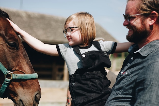 Little girl petting a horse