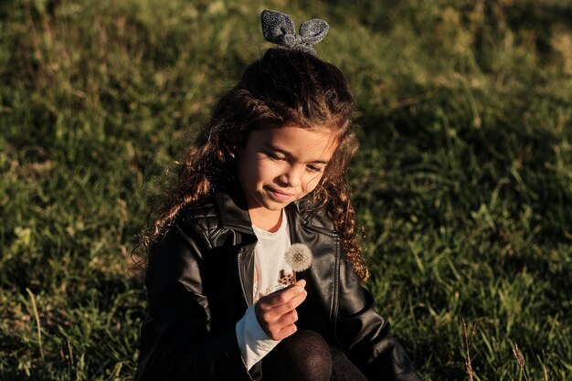 Foto bambina che raccoglie fiori nel campo da soffiare