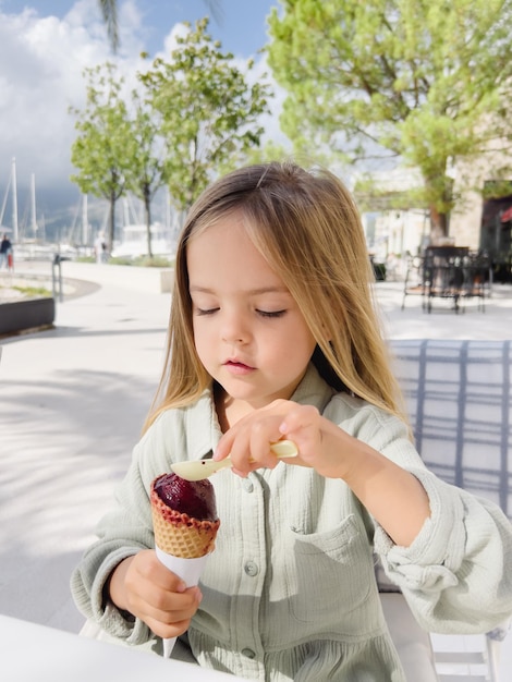사진 작은 소녀는 스파라로 와플 콘에 있는 아이스크림을 집어 들인다