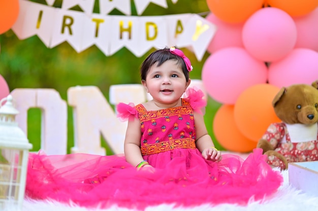 a little girl in a pink dress with the words happy birthday on it