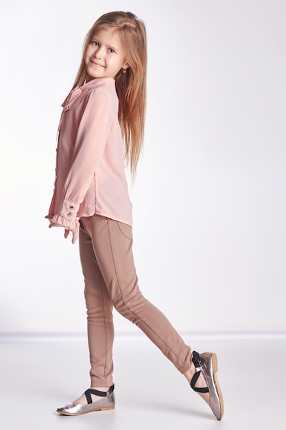 Little girl in a pink shirt and pants posing 