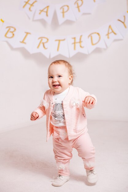 A little girl in a pink suit celebrates her birthday