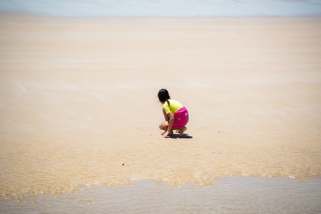 ビーチで小さな女の子が遊ぶ