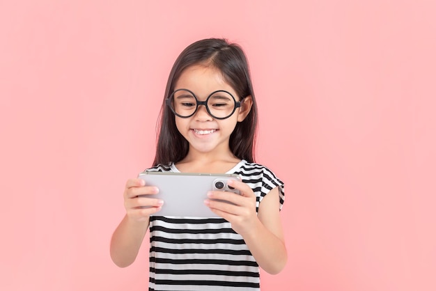 Little girl play phone mobile Isolated on pink background