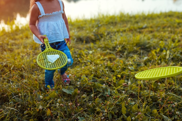 夏の公園で妹とバドミントンをする少女