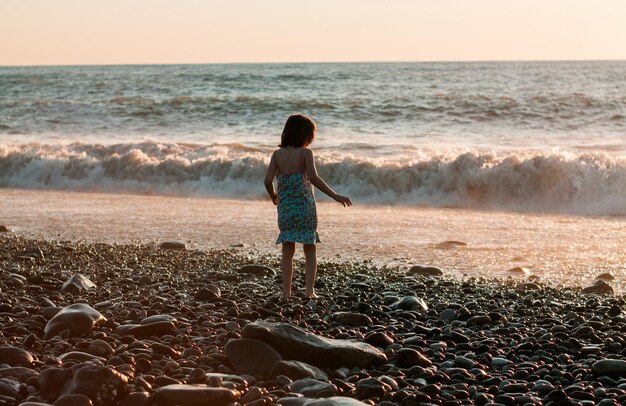 Photo little girl playing at the beach