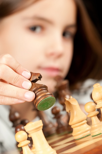 маленькая девочка играет в шахматы