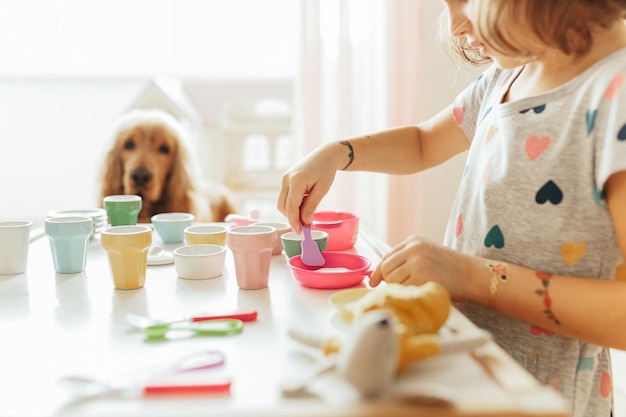 子供用食器で遊ぶ少女