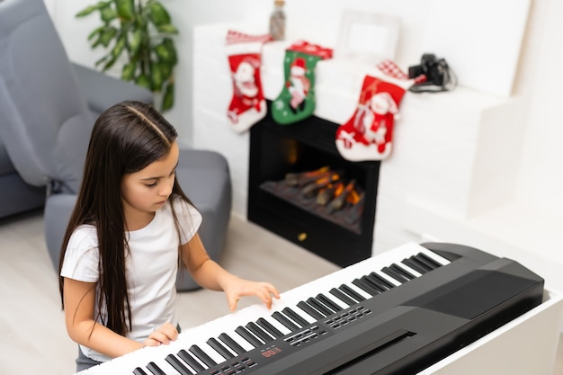 little girl playing electric piano at christmas