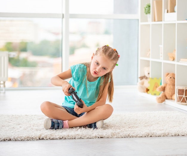 Little girl playing games with joystick