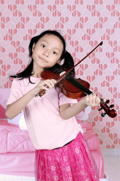 Photo little girl playing a music with a violin