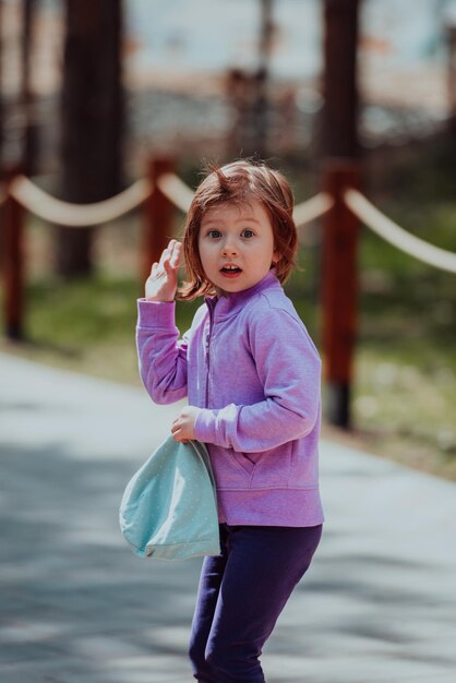 公園で遊ぶ少女。公園での家族の社交のコンセプト。女の子がブランコに乗って、クリエイティブなゲームをします。