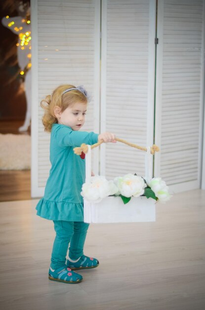 Little girl playing in the room with christmas decorationsand wrapped presents