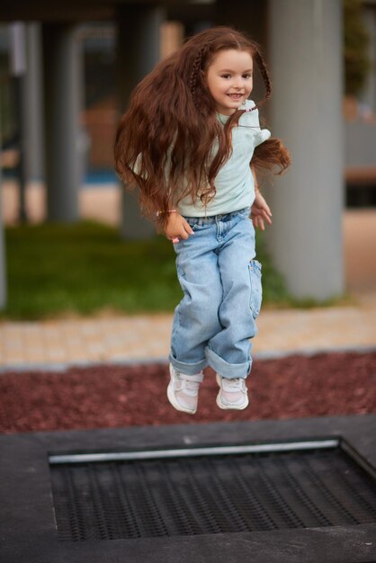 Photo little girl playing on the slider little pretty girl is having fun outdoor happy preschool little kid