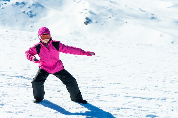 Foto bambina che gioca l'istruttore dello snowboard su neve