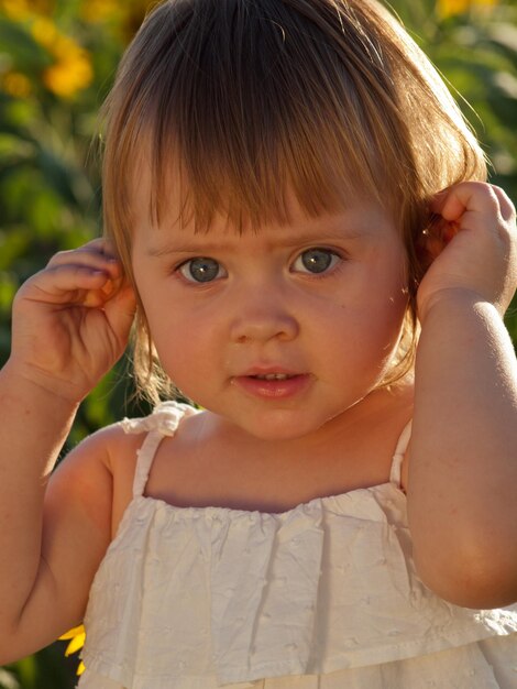 Little girl playing in sunflower field.