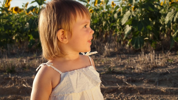 Маленькая девочка, играя в поле подсолнечника.