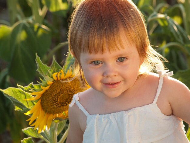 Little girl playing in sunflower field.