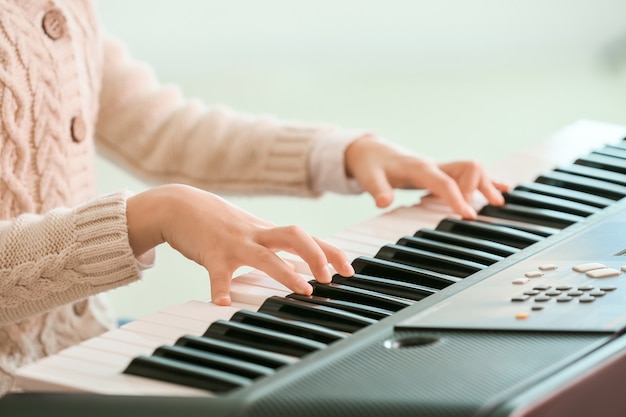 Bambina che gioca sintetizzatore a casa, primo piano