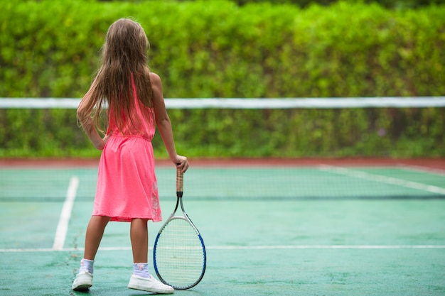 写真 少女がコートでテニスをしています