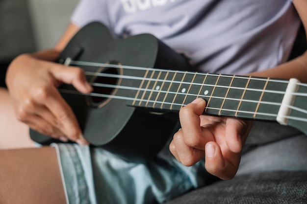 Little girl playing ukulele Concept art and music Focus on hand