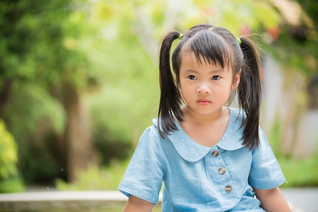 暑い夏の日にカラフルな庭で水を再生する少女。