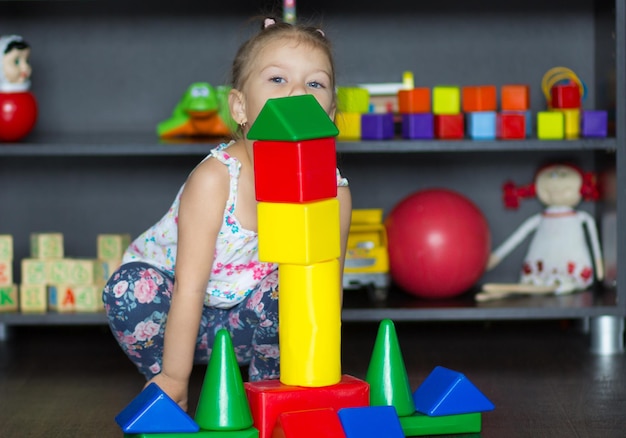 Little girl playing with big multicolor plastic blocks