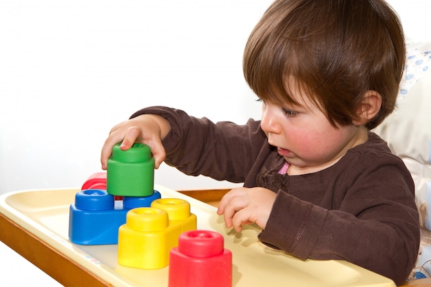 Little girl playing with colorful blocks