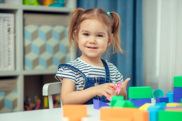 カラフルなおもちゃのブロックで遊ぶ少女