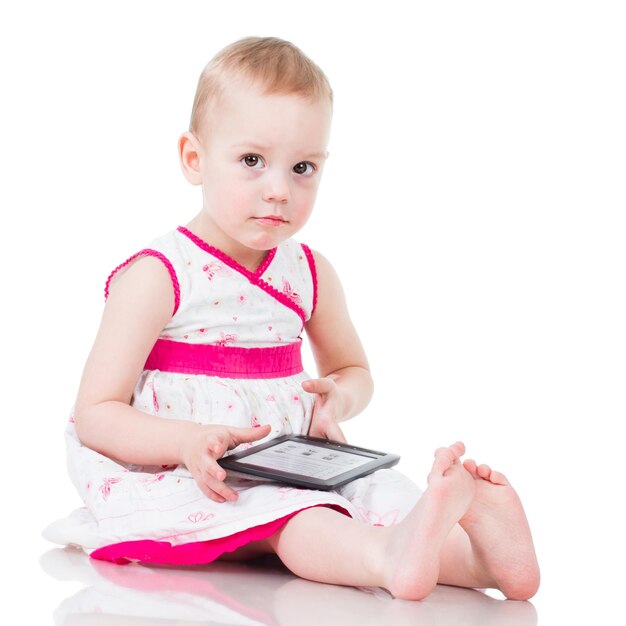 Little girl playing with a digital tablet