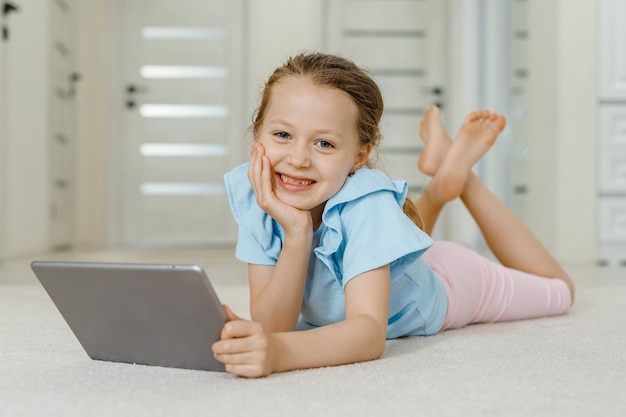 Little girl playing with digital wireless tablet computer at home Baby child growing with online applications Child and electronic devices concept Portrait of toddler with smartphone