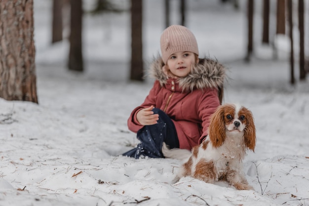 Little girl playing with dog on the street