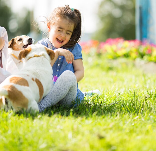 Little girl playing with dogs