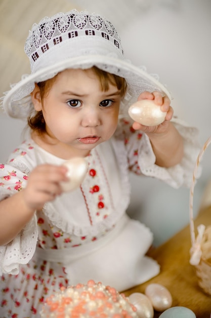Маленькая девочка играет с пасхальными яйцами