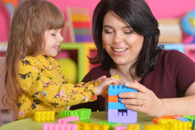 Little girl playing with mother at home