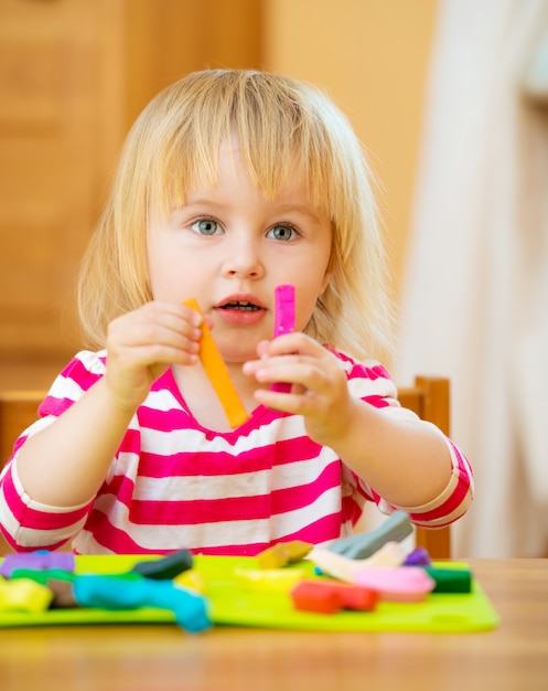 Little girl playing with plasticine