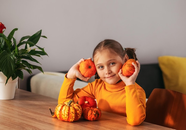 自宅でカボチャの感情的な肖像画で遊ぶ少女ハロウィン パーティー コンセプト