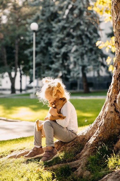 屋外で子犬と遊ぶ少女