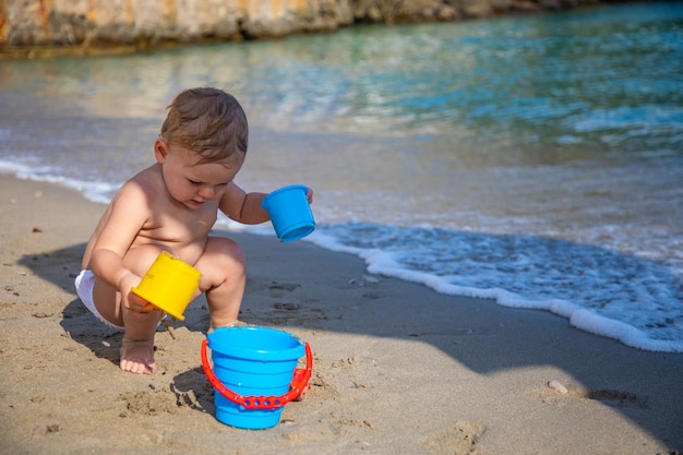 Маленькая девочка играет с песком на пляже, наслаждаясь прекрасным отдыхом