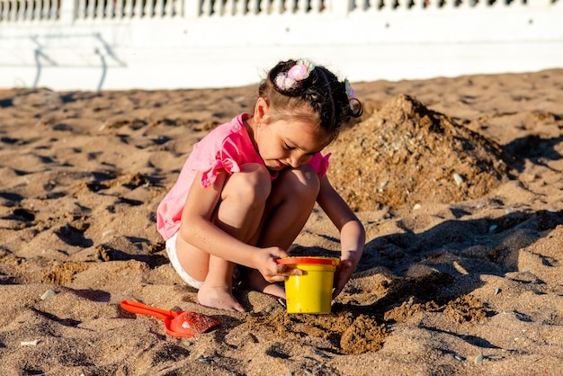 写真 ビーチで砂で遊ぶ少女