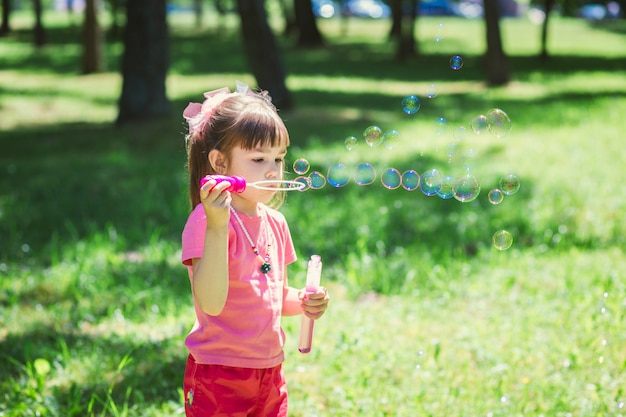 Little girl playing with soap bubbles 