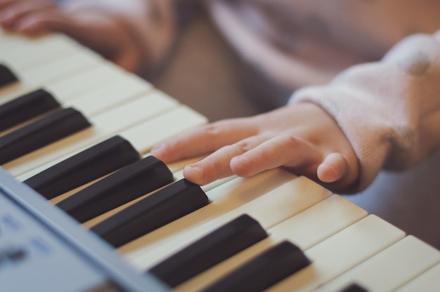 A little girl plays the electric piano