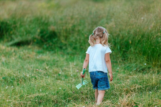 小さな女の子がフィールドで遊ぶ