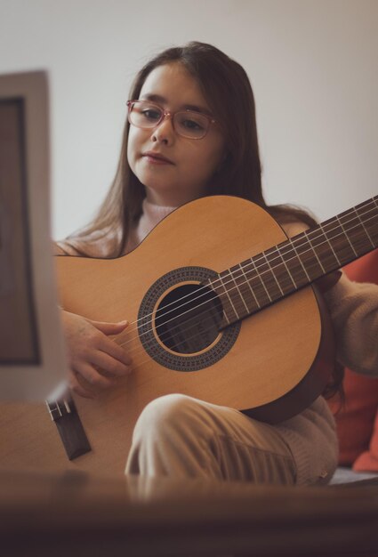 Photo little girl plays the guitar