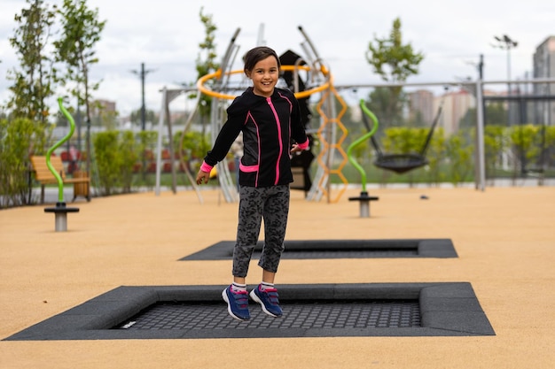 Little girl plays on a trampoline sports ground