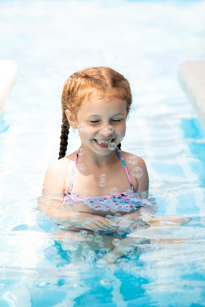 A little girl in a pool of blue water Vacation