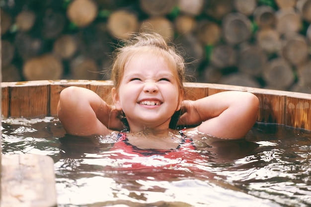 Foto una ragazzina in una piscina con gli occhi chiusi e un sorriso sul viso